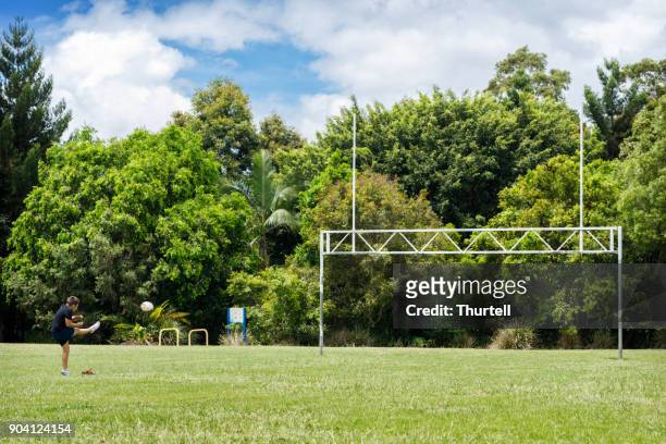 young aboriginal boy practising rugby goal kicking - rugby league stock pictures, royalty-free photos & images
