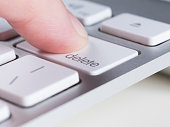 Finger is pressing delete key of computer keyboard