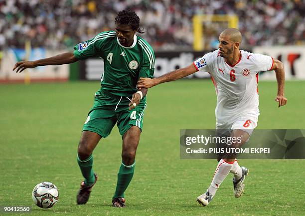 Nigerian captain Kanu Nwankwo competes with Ragued Houcine of Tunisia during the World Cup qualification match in Abuja on September 6, 2009. Tunisia...