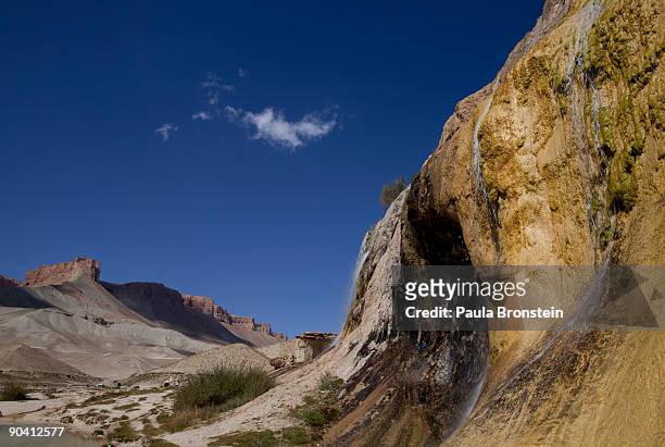 Waterfall created by natural "travertine" dams contrasts the high desert red rock cliffs at Band-E-Amir National Park September 6, 2009 in...