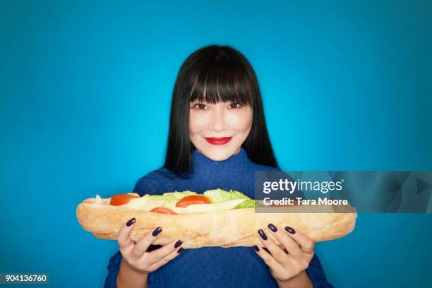 woman holding large sandwich - beautiful woman waist up stock pictures, royalty-free photos & images