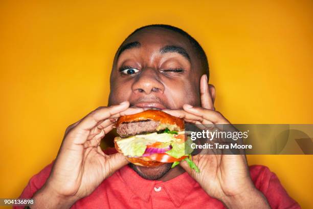 man eating hamburger - burger stock-fotos und bilder