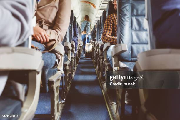 vliegtuig interieur met mensen zitten op stoelen - airplane interior stockfoto's en -beelden