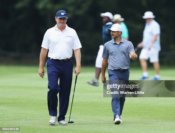 Ernie Els and Trevor Immelman of South Africa walk on the 7th fairway during day two of the BMW South African Open Championship at Glendower Golf...