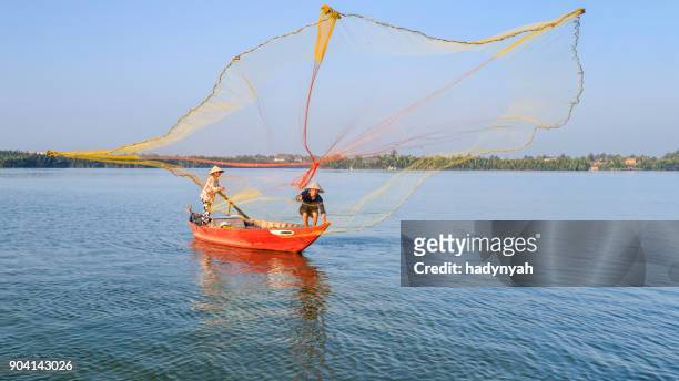 vietnamese man catching fishes in thu bon river near hoi an, central vietnam - asian style conical hat stock pictures, royalty-free photos & images