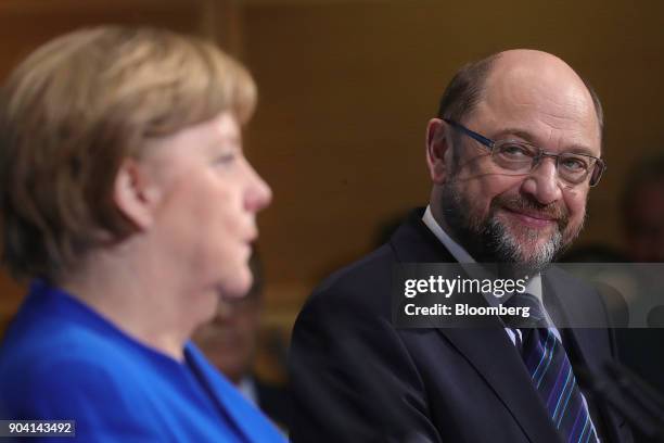 Martin Schulz, leader of the Social Democrat Party , right, looks towards Angela Merkel, Germany's chancellor, during a news conference following...