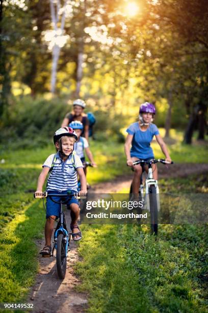 héhé, appréciant la balade à vélo dans le parc - famille a velo photos et images de collection