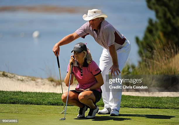 Greg Norman helps his junior partner Melissa Edmonson line up a putt on during the final round of the Walmart First Tee Open at Pebble Beach on...