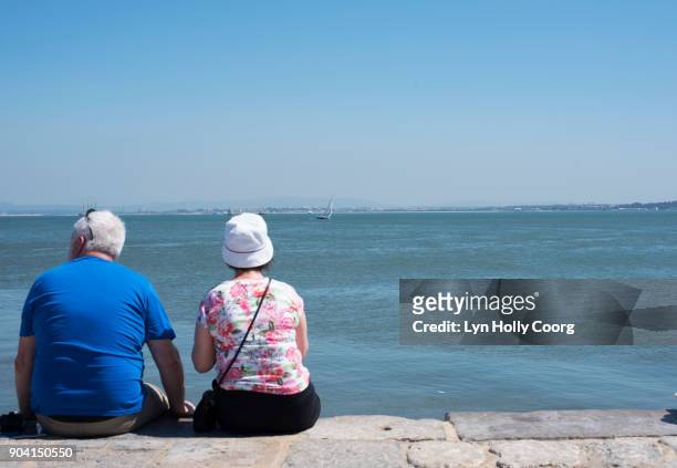 a senior couple looking out over the tagus river lisbon . - lyn holly coorg stock pictures, royalty-free photos & images