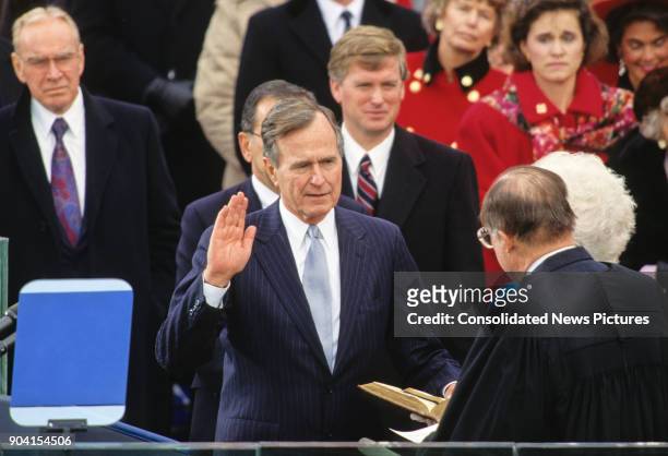 American politician George HW Bush takes the oath of office as he is sworn-in as 41st President of the United States by Chief Justice William...