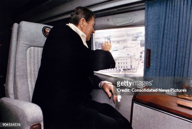 Aboard US Marine helicopter 'Nighthawk 1,' former President Ronald Reagan waves out the window as he departs from the US Capitol after President...
