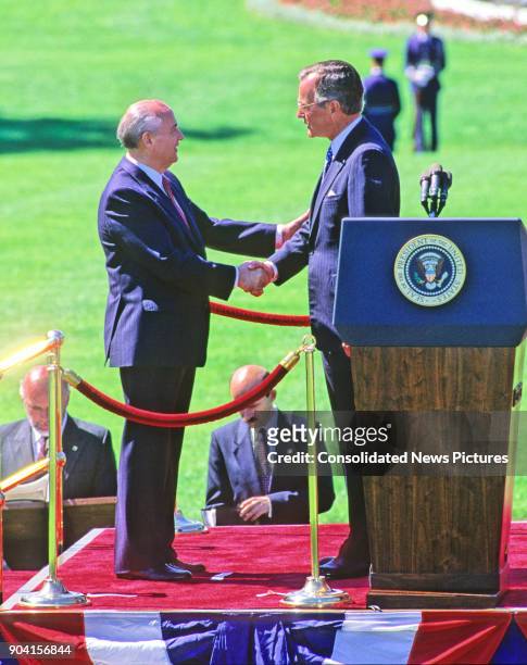 On the White House's South Lawn, Soviet President Mikhail Gorbachev and US President George HW Bush shake hands during the arrival ceremony in honor...