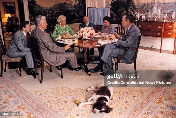 Russian President Boris Yeltsin and US President George HW Bush , along with their wives, First Lady Barbara Bush and Naina Yeltsina, as they talk...