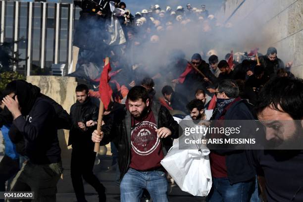 Demonstrators clash with police as they try to take the stairs leading to the parliament building in Athens on January 12 as part of a strike wave...