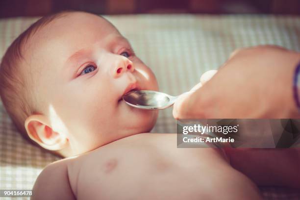 4 month baby boy drinks syrup or water - syrup stock pictures, royalty-free photos & images