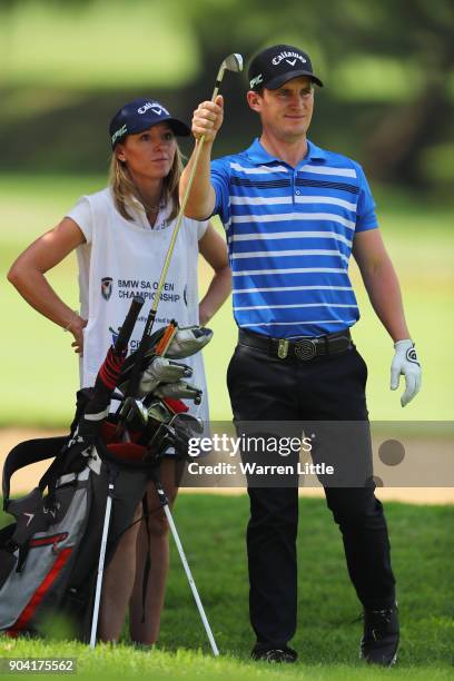 Chris Paisley of England takes a club from his bag with caddie and wife Keri on the 15th hole during day two of the BMW South African Open...