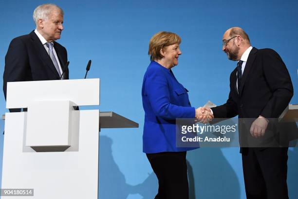 German Chancellor Angela Merkel shakes hands with Social Democratic Party, SPD chairman Martin Schulz as they flanked by Bavarian Prime Minister...