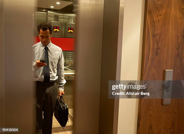 businessman in lift. - ascenseur interieur photos et images de collection