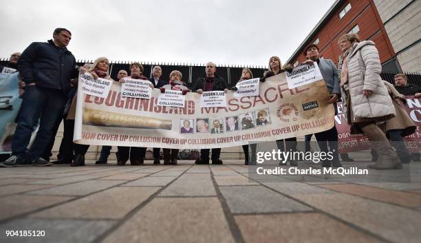 Loughinisland victim family members stand with a banner outside Belfast High Court on January 12, 2018 in Belfast, Northern Ireland. The judge has...
