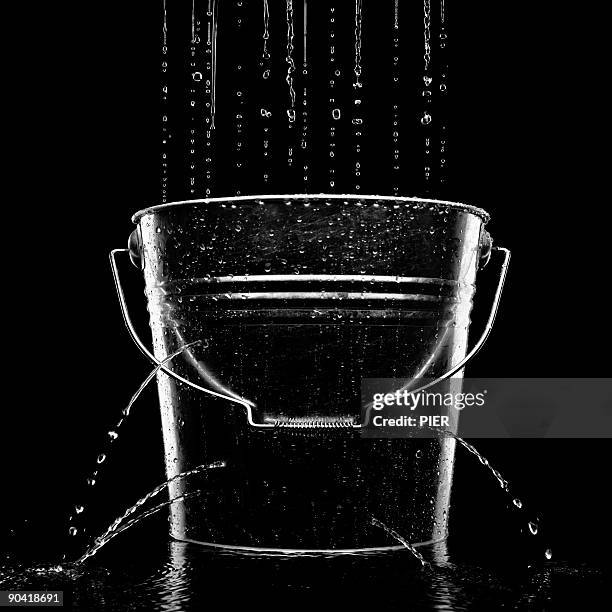 water falling into a leaking metal bucket - undicht stock-fotos und bilder