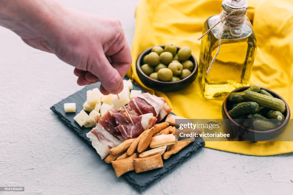 Mans hand reaching for Spanish tapas