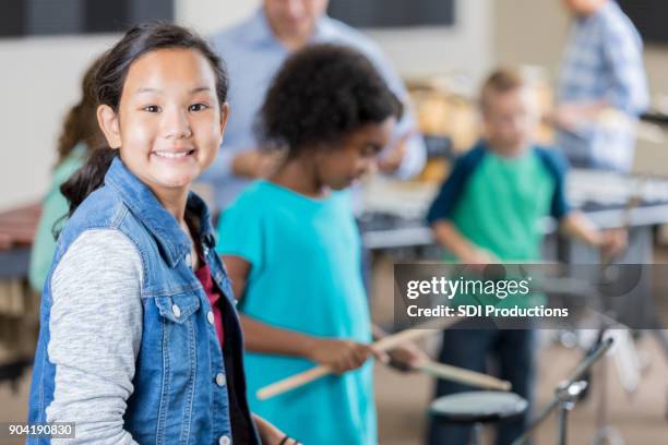 écolière confiant, jouer de la batterie au cours de la classe de musique - percussion mallet photos et images de collection