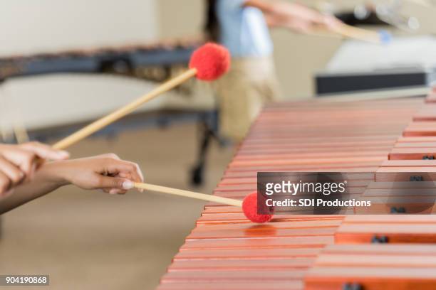 unrecognizable student playing marimba during band practice - xylophone stock pictures, royalty-free photos & images