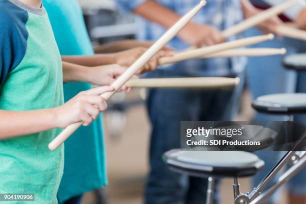 onherkenbaar schoolkinderen beoefenen van de drums - drumstok stockfoto's en -beelden
