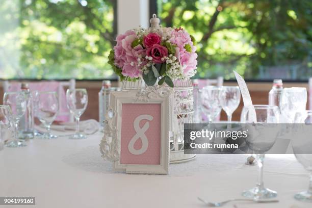 floral centerpiece on a table - table numbers stock-fotos und bilder