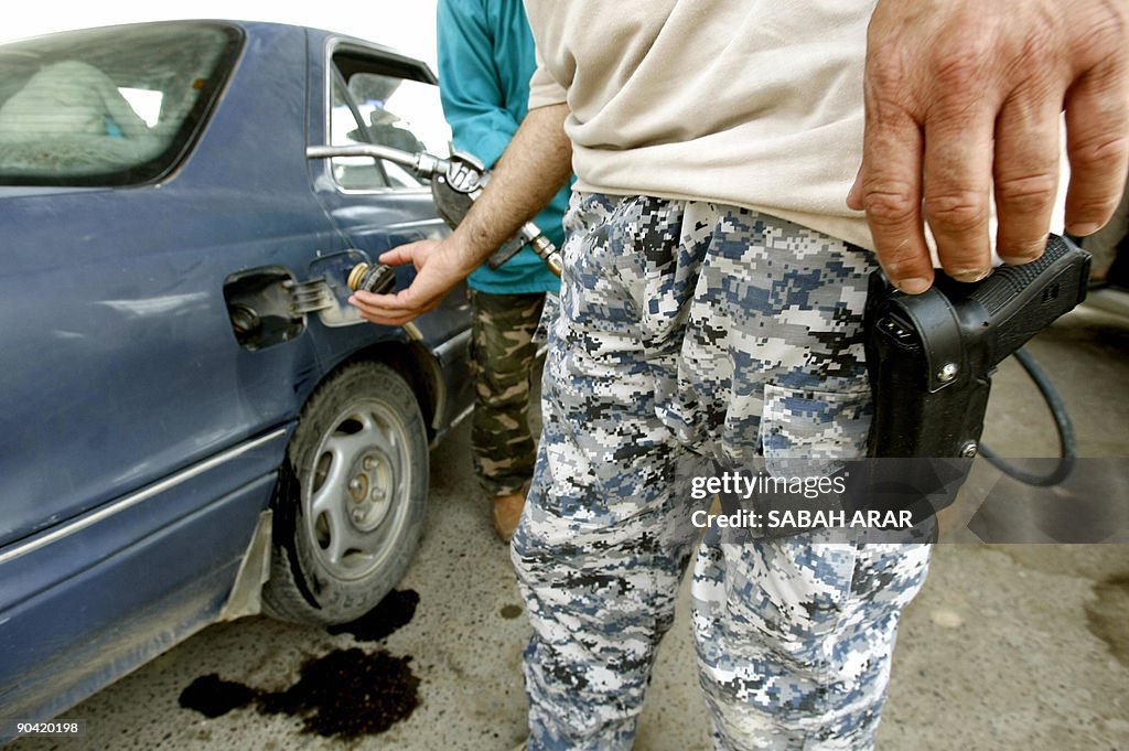 A police officer fills his car up at a l