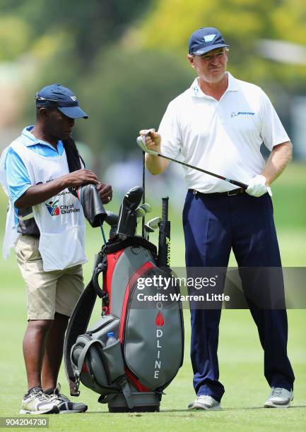 Ernie Els of South Africa takes a club from his bag with his caddie on the 7th hole during day two of the BMW South African Open Championship at...