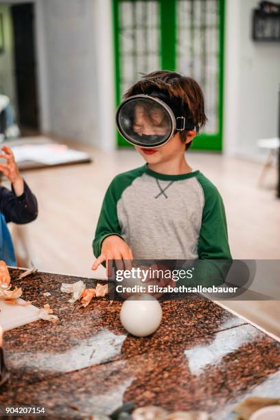 boy wearing a diving mask peeling onions - scuba mask stock pictures, royalty-free photos & images