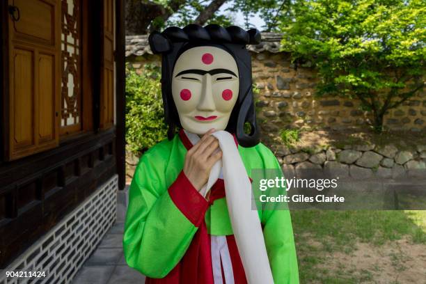 South Korean woman in traditional Korean clothing and a mask. The Hahoe Folk Village is a traditional village from the Joseon Dynasty. The 'Ha' is...