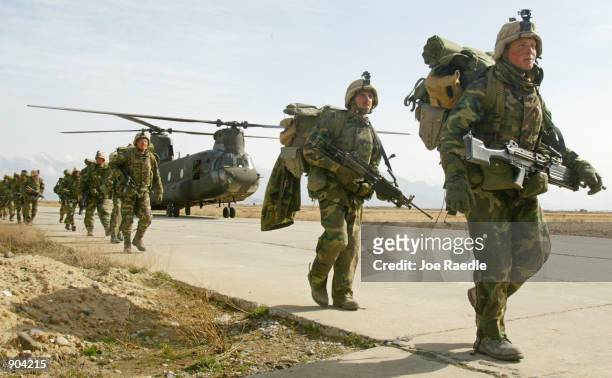 Army soldiers from the 10th Mountain and the 101st Airborne units disembark from a Chinook helicopter March 11, 2002 as they return to Bagram airbase...