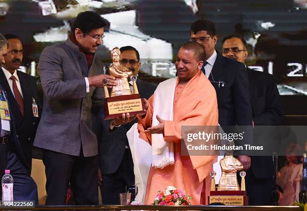 Uttar Pradesh Chief Minister Yogi Adityanath receiving Small statue of Swami Vivekanand by Cabinet Minister of Youth Affairs and Sports Rajyavardhan...