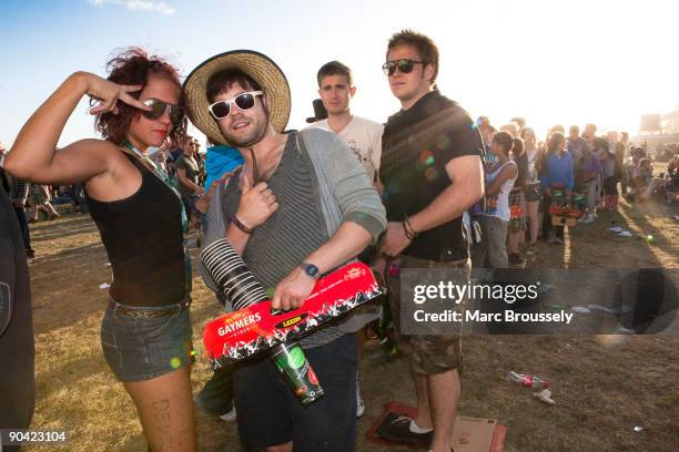 Group of festival goers wearing sunglasses and holding a stack of empty beer cups pose in the crowd at the Reading Festival on August 29, 2009 in...