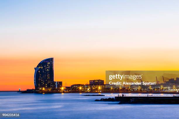 illuminated barcelona skyline at dusk - barceloneta beach stock pictures, royalty-free photos & images