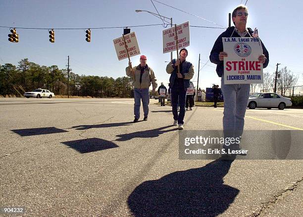 Members of the International Association of Machinists Local 709 walk the picket line March 11, 2002 in front of the Lockheed Martin aircraft...