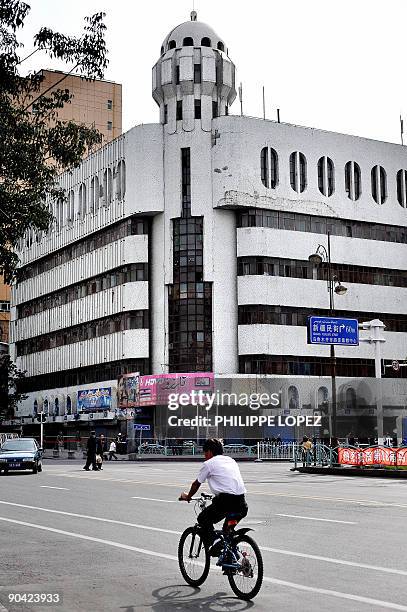 China-unrest-Xinjiang-Kadeer-buildings BY DAN MARTIN In a picture taken on September 5, 2009 a man cycles past The Kadeer Trade Centre in Urumqi, in...