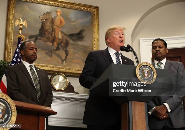 President Donald Trump speaks while flanked by HUD Secretary Dr. Ben Carson and Isaac Newton Farris, Jr., before signing a proclamation to honor...