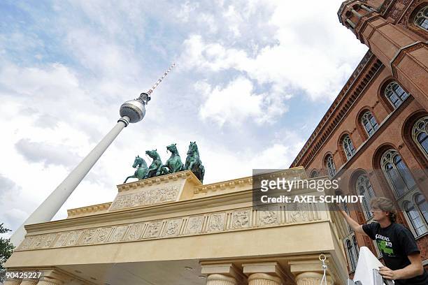 An employee checks a model of the Brandenburg Gate in front of Berlin's town hall on September 7, 2009. The model was created for a court festival at...