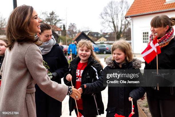 Crown Princess Mary of Denmark speaks to kids with the Danish flag at her arrival to the Christmas Seal Foundation home opening on January 12, 2018...