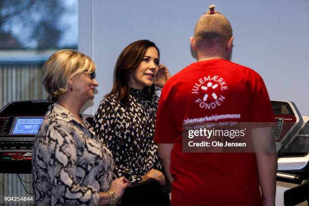 Crown Princess Mary of Denmark speaks to a young boy doing physical exercise during the Christmas Seal Foundation home opening on January 12, 2018 in...