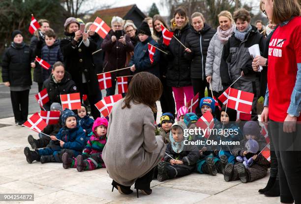 Crown Princess Mary of Denmark speaks to kids with the Danish flag at her arrival to the Christmas Seal Foundation home opening on January 12, 2018...