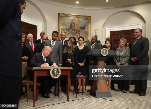 President Donald Trump is flanked by members of the African American community while signing a proclamation to honor Martin Luther King, Jr. Day, in...