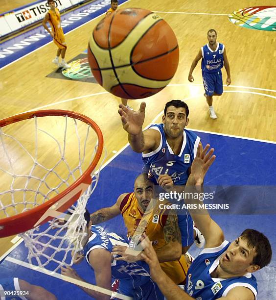 Greece's Ioannis Bourousis and Antonis Fotsis fight for the ball with F.Y.R. Of Macedonia's Pero Antic during their 2009 European championship...