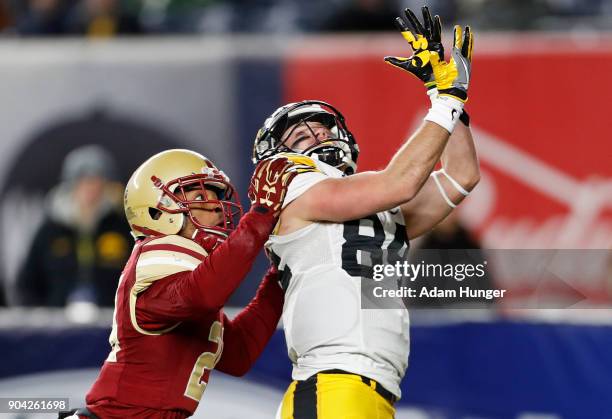 Nick Easley of the Iowa Hawkeyes looks to make a catch in front of Taj-Amir Torres of the Boston College Eagles during the second half of the New Era...