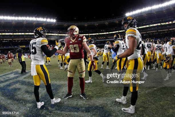 Joshua Jackson of the Iowa Hawkeyes consoles Charlie Callinan of the Boston College Eagles after the New Era Pinstripe Bowl at Yankee Stadium on...
