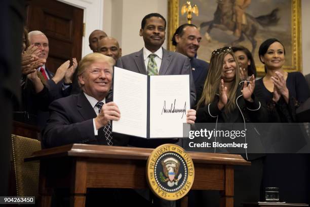 President Donald Trump holds up a signed proclamation for Martin Luther King Jr. Day in the Roosevelt Room of the White House in Washington, D.C.,...