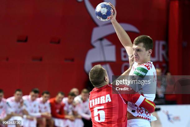 Uladzislau Kulesh of Belarus vies for the ball with Vytautas Ziura of Austria during the preliminary round group B match of the Men's 2018 EHF...
